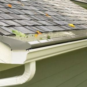 A seamless gutter system and gutter guards adhered to a grey shingle roofline